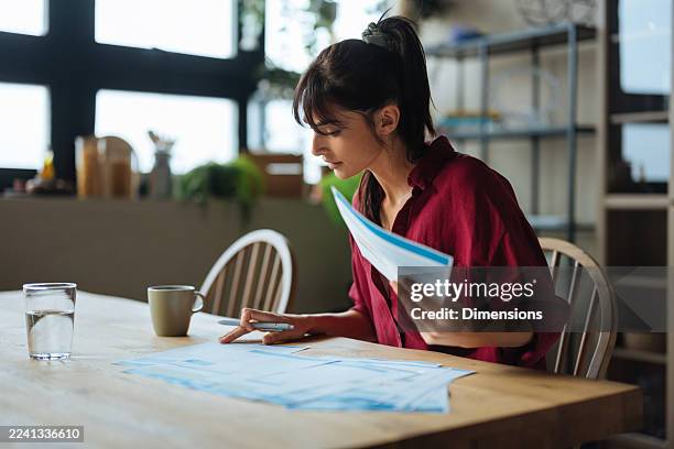 woman examining home bills and managing personal finances - spreadsheet stock pictures, royalty-free photos & images