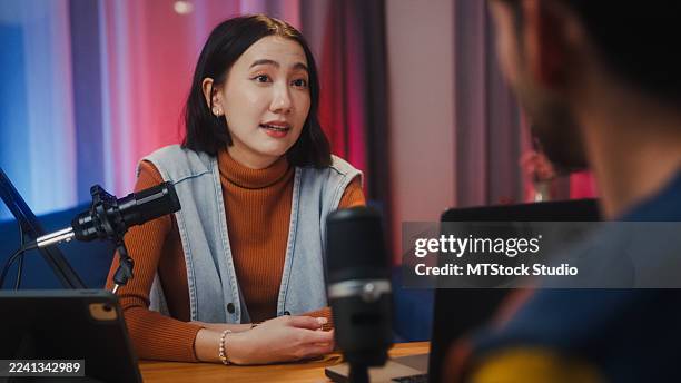 primer plano de podcasters de la generación z colaborando con auriculares discutiendo temas durante la sesión de grabación juntos en el estudio en casa por la noche. - maestro de ceremonias fotografías e imágenes de stock