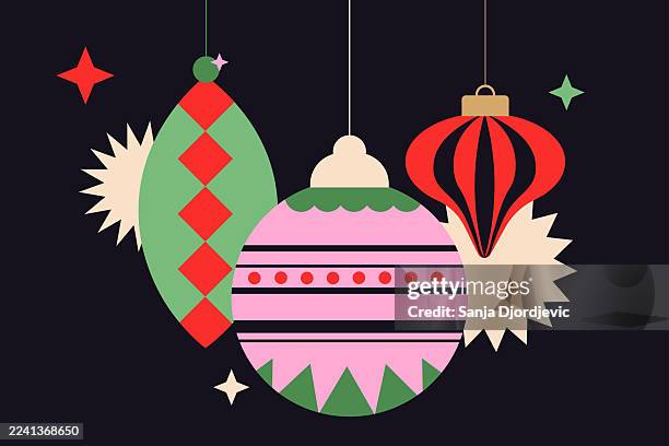 christmas ornaments hanging ball ornaments with green, red, and pink decorations against dark background - christmas bunting stock illustrations