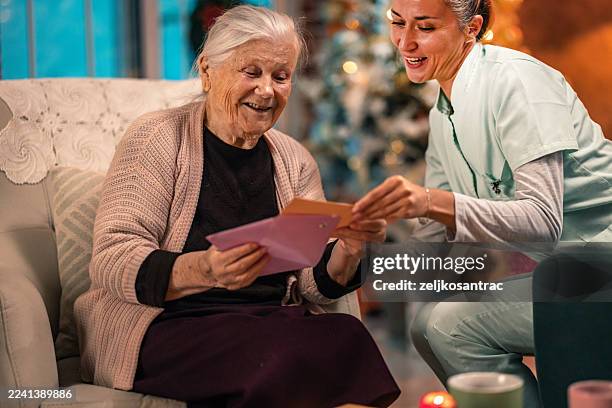 senior woman handwriting a christmas or new year greeting card - new year card stock pictures, royalty-free photos & images