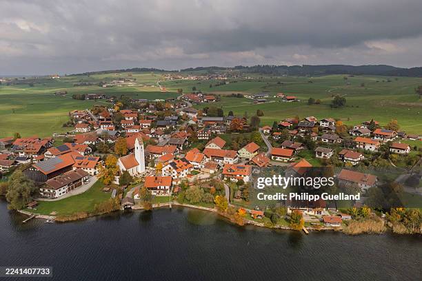 In this aerial view taken with a drone solar panels lie installed on roofs of residential houses on October 16, 2025 in Riegsee, Germany. The state...