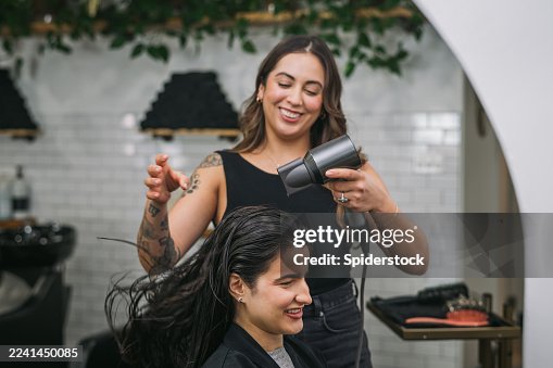 Female Stylist Blowing Out Woman's Hair at a Salon Female Stylist Blowing Out Woman's Hair at a Salon