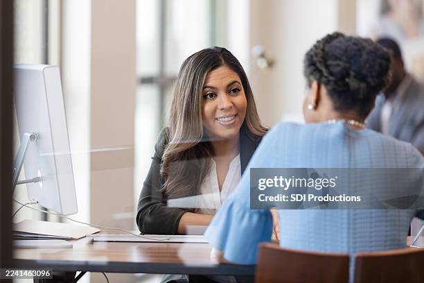 geschäftsfrauen, die am schreibtisch mit computer in modernem büromeeting zusammenarbeiten - bankdirektor stock-fotos und bilder