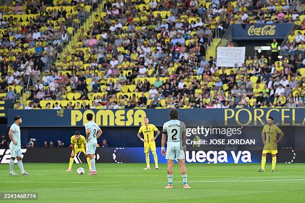 Players stand on the pitch in a symbolic protest against the proposed relocation of the Villarreal-Barcelona match to Miami, at the start of the...
