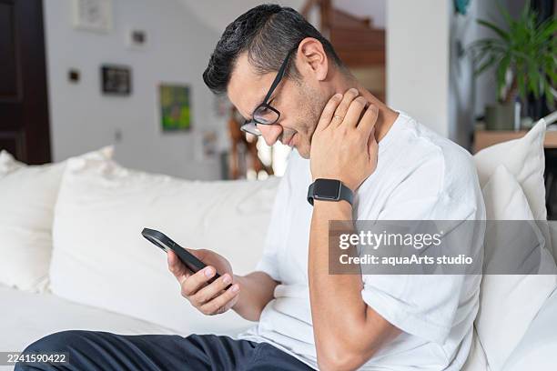 man suffering from neck pain while using smartphone too long - medical mistake stock pictures, royalty-free photos & images