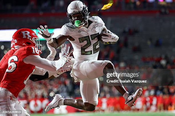 Jay Harris of the Oregon Ducks reaches to stiff arm Jesse Ofurie of the Rutgers Scarlet Knights as a penalty flag is called during the third quarter...
