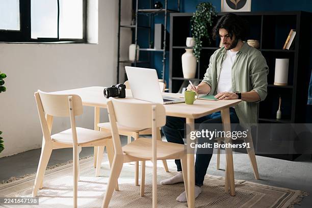 young man sitting at desk and working from home - average photo editing by professional photographers stock pictures, royalty-free photos & images