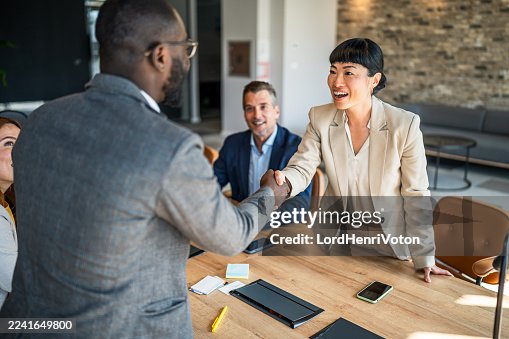 Business partners shaking hands making international agreement Business partners shaking hands making international agreement