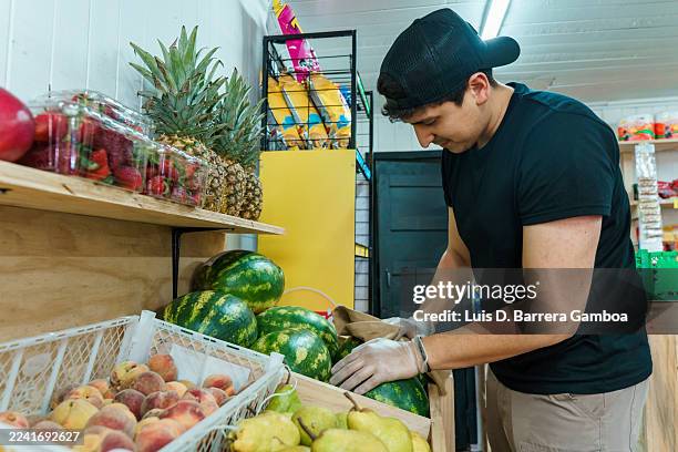 latin american man working in small business greengrocer - grocer stock pictures, royalty-free photos & images