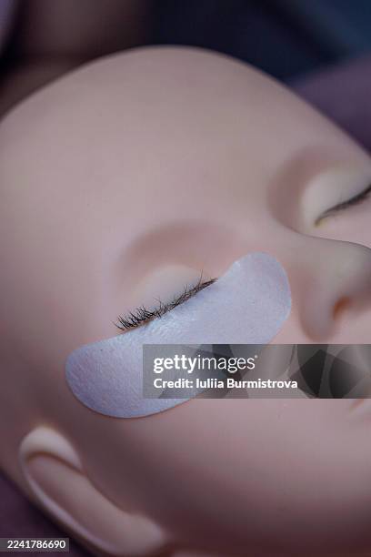 close up of a model's eye with an under-eye patch during eyelash extension treatment - hyperpigmentation stockfoto's en -beelden