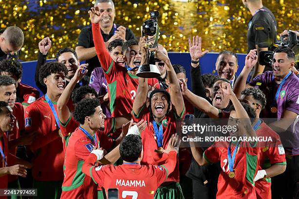 Morocco's players celebrate with the trophy after winning the 2025 FIFA U-20 World Cup final football match between Argentina and Morocco at the...