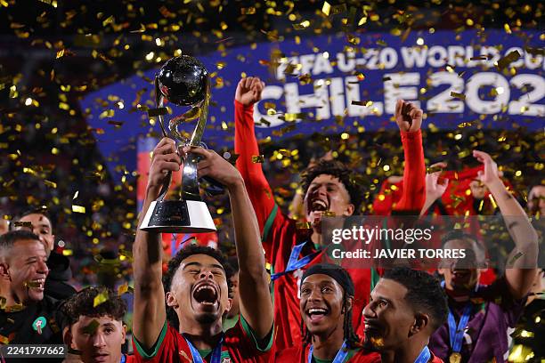 Morroco's team members celebrate with the trophy after winning the 2025 FIFA U-20 World Cup final football match between Argentina and Morocco at the...