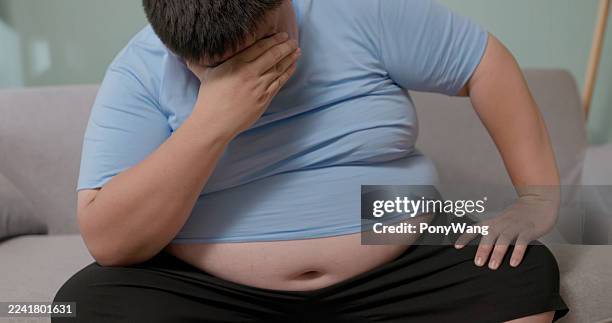 obese man feeling stressed at home - obesity stock pictures, royalty-free photos & images