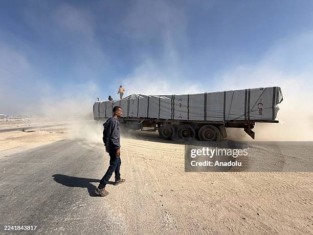 Aid trucks, carrying food and fuel aid, under the supervision of international organizations affiliated with the United Nations, reach Deir Al Balah...