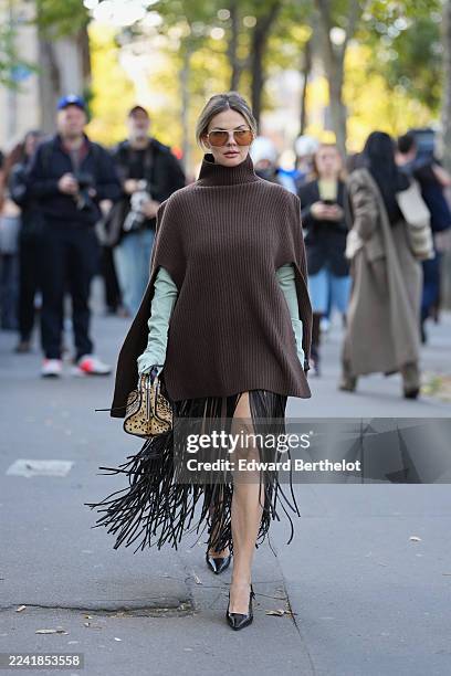 Guest wears a pulled-back low bun of medium-length light brown hair with blonde highlights, oversized aviator sunglasses with brown gradient lenses...