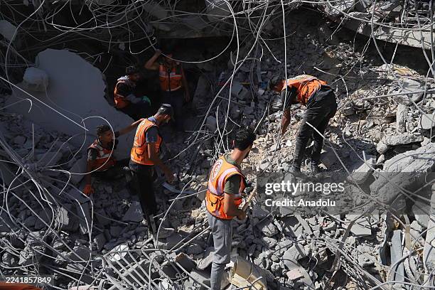 Civil defense teams conduct search and recovery operations to retrieve the bodies of Palestinians from the rubble of buildings destroyed by Israeli...