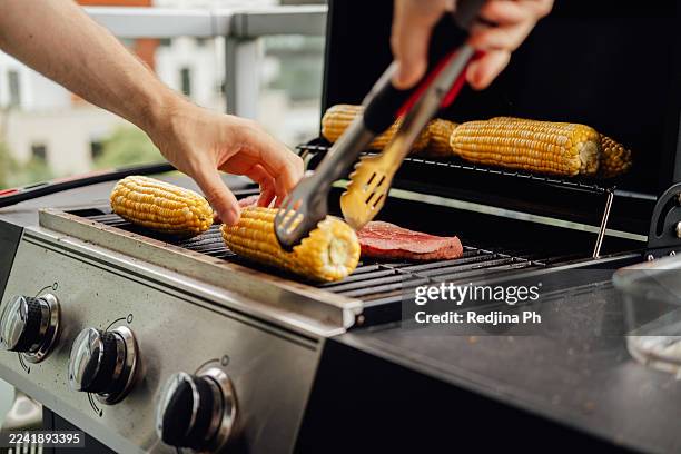 grilling corn on the cob and steak on bbq - corn cob stock pictures, royalty-free photos & images