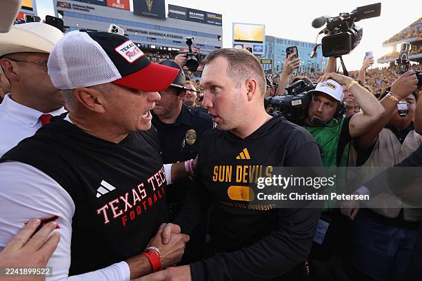 Head coaches Kenny Dillingham of the Arizona State Sun Devils and Joey McGuire of the Texas Tech Red Raiders shake hands after the Sun Devils...