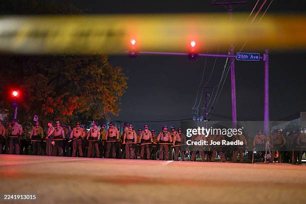 Police interact with demonstrators near the "Free Speech Zone" after a curfew went into effect outside of the immigrant processing and detention...
