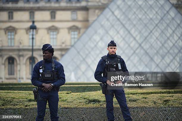Police stand guard outside the Louvre museum at Louvre on October 19, 2025 in Paris, France. France's Culture Minister, Rachida Dati, announced the...
