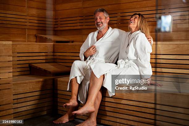 couple laughing, enjoying sauna together, relaxing at spa - sauna stockfoto's en -beelden