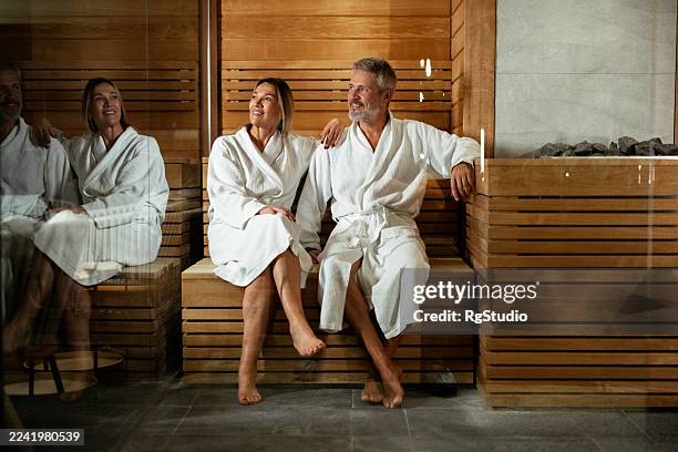 couple relaxing in sauna enjoying a health spa treatment - kuuroord stockfoto's en -beelden