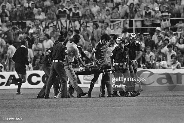 French defender Patrick Battiston is comforted by teammate Michel Platini while evacuated from the pitch during 1982' World Cup semifinal France-West...