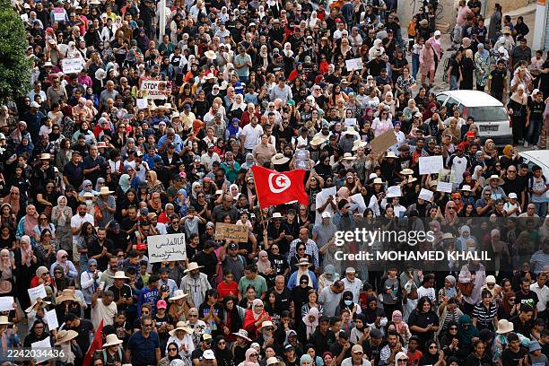 Protesters carry placards and wave national flags as they march in the southern city of Gabes on October 21, 2025. Workers in Gabes launched a...