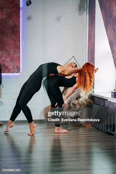 two women doing partner acroyoga backbend pose - double jointed stock pictures, royalty-free photos & images