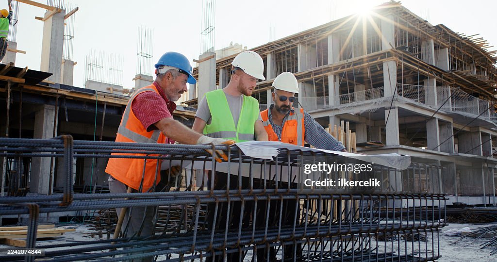 Civil engineer, foreman and master are discussing on the progress plan and the project at construction site