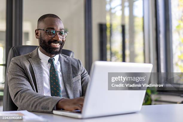 professional man working on a laptop in a bright office - email window stock pictures, royalty-free photos & images