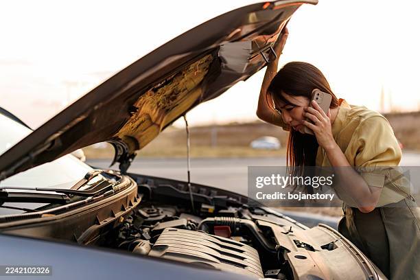 asian woman calling for roadside assistance after car breakdown on the side of the road - stranded stock pictures, royalty-free photos & images