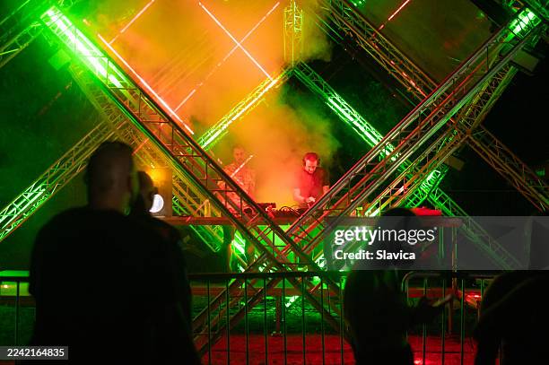 two club dj's playing techno music on the summer concert - laser light show stock pictures, royalty-free photos & images