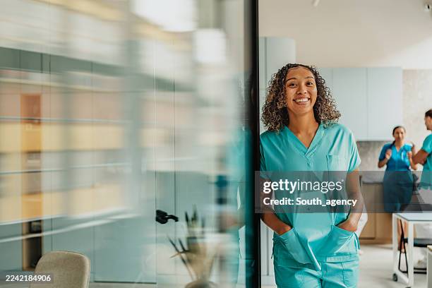 mitarbeiter des gesundheitswesens arbeiten in einer fröhlichen umgebung in einer modernen medizinischen klinik zusammen - medizinerkleidung stock-fotos und bilder