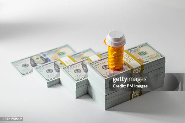 rising cost of prescription medication - pill bottle on money - expense stock pictures, royalty-free photos & images