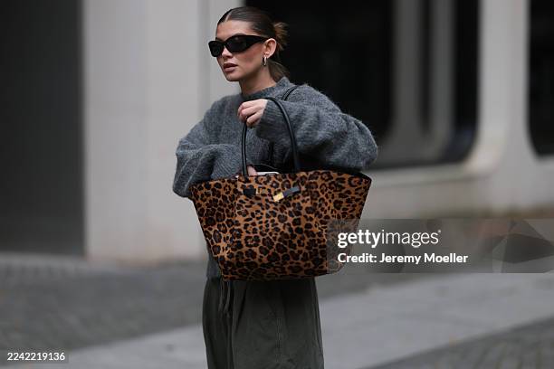 Sophia Geiss with a brown haired sleek bun seen wearing a grey oversized LeGer sweater styled with khaki Frankie Shop cargo wide pants, black LeGer...