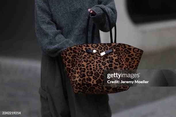 Sophia Geiss with a brown haired sleek bun seen wearing a grey oversized LeGer sweater styled with khaki Frankie Shop cargo wide pants, black LeGer...