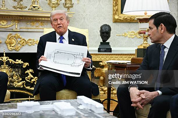 President Donald Trump shows the floor plan of his planned ballroom as he meets with NATO Secretary General Mark Rutte in the Oval Office of the...