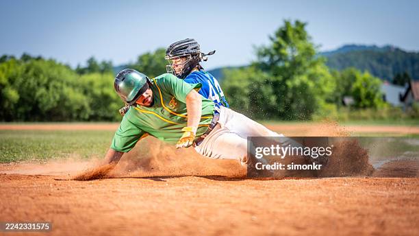caucasian baseball player sliding to home base with determination - baseball team stock pictures, royalty-free photos & images