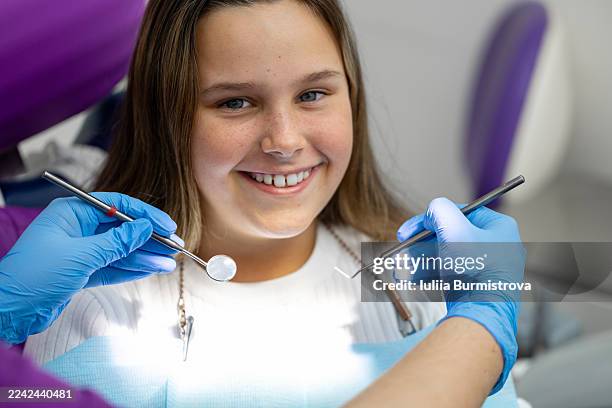 happy young patient at the dentist with gloved hands and dental tools ready for a checkup - dentin stock pictures, royalty-free photos & images