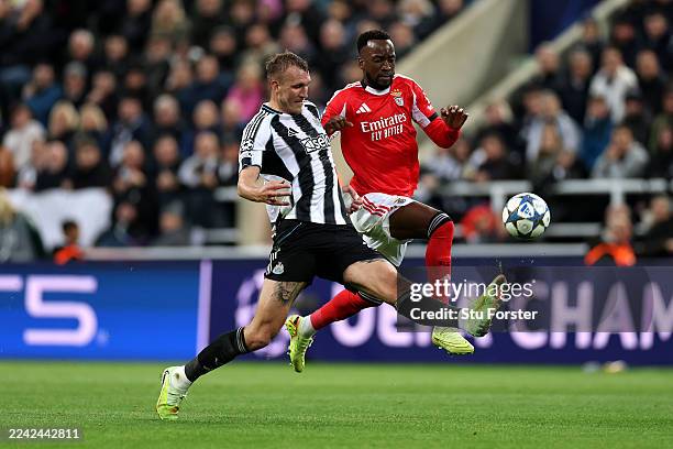 Dan Burn of Newcastle United battles for possession with Dodi Lukebakio of Benfica during the UEFA Champions League 2025/26 League Phase MD3 match...
