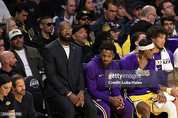 LeBron James and Bronny James of the Los Angeles Lakers look on from the bench during the second quarter of the game against the Golden State...
