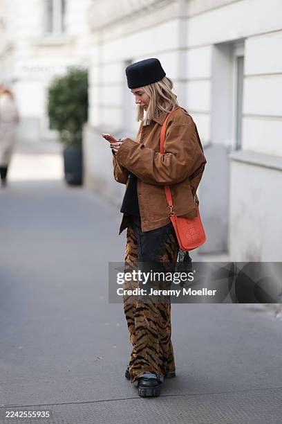Karin Teigl with blonde straight and short hair seen wearing a cropped Prada jacket in sleek black leather with a structured silhouette and silver...