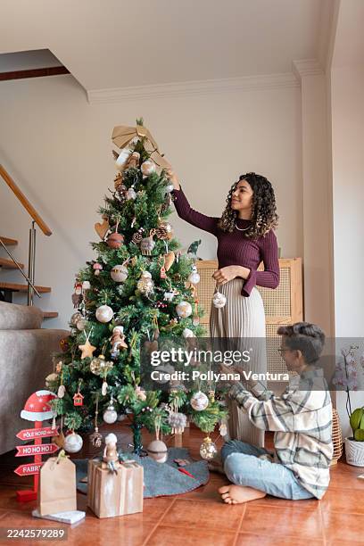 siblings decorating the christmas tree - 12 17 months stock pictures, royalty-free photos & images
