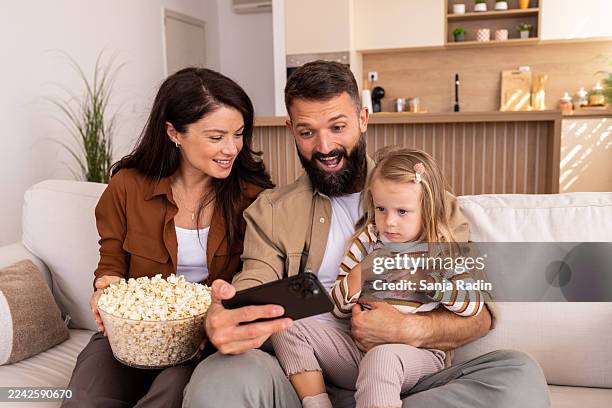 family enjoying weekend video time - snack time cartoon stock pictures, royalty-free photos & images
