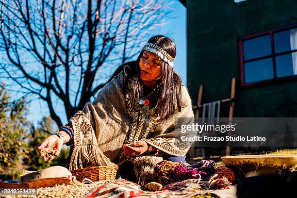 mature mapuche woman preparing a religious offering outdoors - south american culture stock pictures, royalty-free photos & images