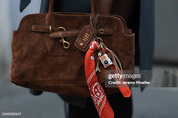 Karin Teigl, with blonde short straight hair, seen wearing a cozy H&M Studio sweater in a brown and black pattern, paired with matching black high...