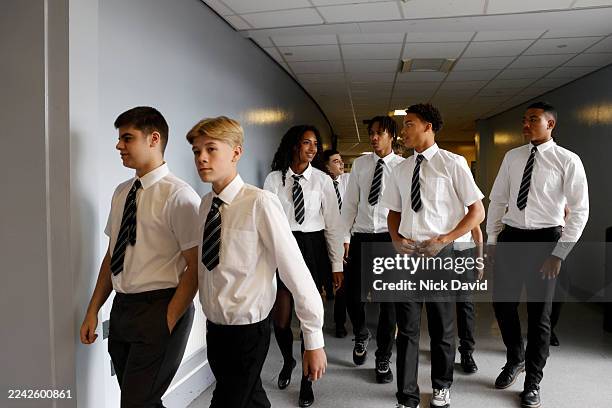 a mixed group of secondary school students dressed in their uniforms walk out of an examination hall. - school uniform stock pictures, royalty-free photos & images