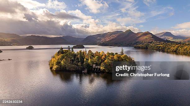 In this aerial view Derwent Isle on Derwentwater shows its autumn colours and hues on October 22, 2025 in Keswick, England. Autumn colours are...