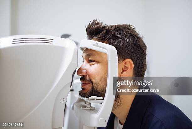 beautiful man during her annual eye test check-up - astigmatism stock pictures, royalty-free photos & images